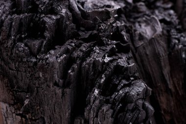 Siyah kömür arka planını kapatın. Ahşap kömür dokusu. Yanmış ağaç