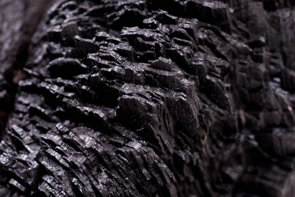 Siyah kömür arka planını kapatın. Ahşap kömür dokusu. Yanmış ağaç
