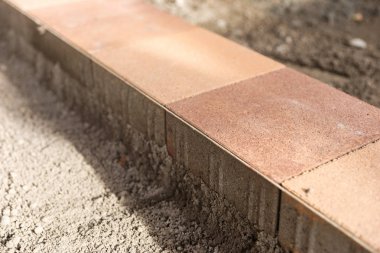 Yeni kaldırım levhaları düz bir yüzey üzerinde yönlendirme kablosu boyunca uzanıyor