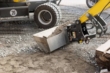 Yol yapımı için betonlu bir kazıcı küreği.