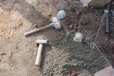 İnşaat kordonu ve çekiç kaldırım için inşaat alanında.