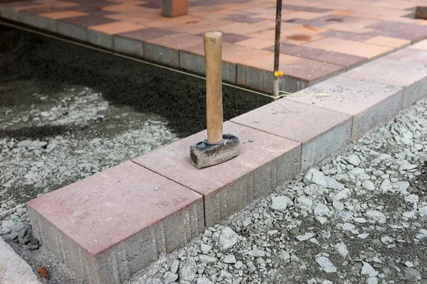 Construction work started. New paving stones and hammer on the construction site