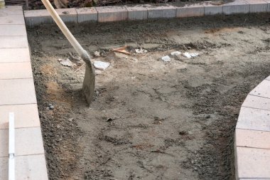 İnşaat işi. İnşaat alanında yeni kaldırım taşı ve kürek