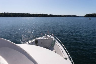 Ön güvertede Amerikan bayraklarını gösteren tur teknesi bin adanın su yolunda ilerliyor.