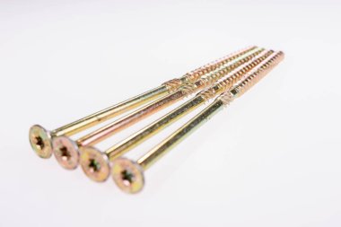 Kafaları öne eğilmiş dört uzun metal vida. Beyaz arkaplanda izole
