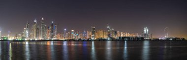 Dubai 'nin gece manzarası, yüksek gökdelenleri ve suyun üzerinde inanılmaz renkleri var.