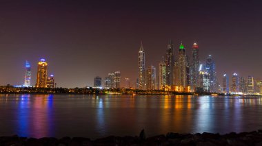 Gece Dubai gökdelenleri. Sudaki ışıklar ve Uae 'nin lüks gökdelenleri.