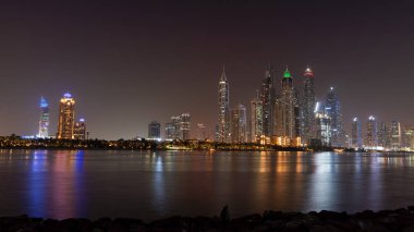 Gece Dubai gökdelenleri. Sudaki ışıklar ve Uae 'nin lüks gökdelenleri.