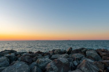 Yellow sunset at the rocky beach shot at summer evening 