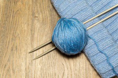 Ahşap arka planda örgü ipliği ve örgü iğneleri. El yapımı hobi. 