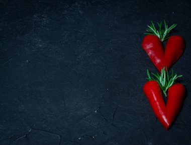 Siyah tahtada ve biberiyede kırmızı biber kalp şekli