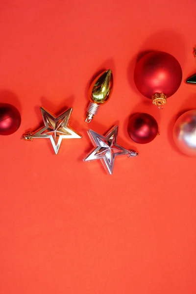 Wystrój świąteczny, czerwone kulki, czerwone i złote gwiazdki na czerwonym tle. — Zdjęcie stockowe