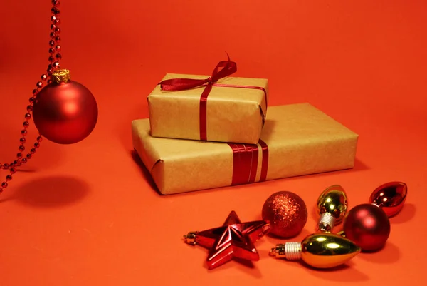 Bola roja de Navidad con cuentas decora las cajas de regalo navideñas. Fondo rojo con juguetes de Navidad . — Foto de Stock