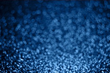 Yan etkisi olan pulların şenlikli bulanık mavi arkaplanı.