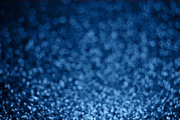 Festive blurry blue background of sequins with side effect.