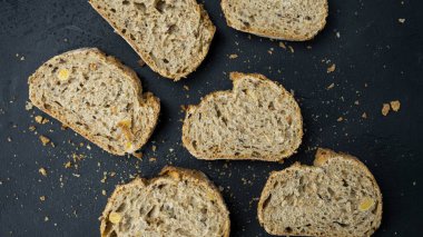 Karanlık arka planda yatan taze ekmeği kes..