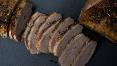 Kızarmış ördek dilimlere ayrılmış. Koyu arkaplan, üst görünüm.