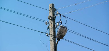 Gökyüzüne karşı elektrik hatları olan bir direk.