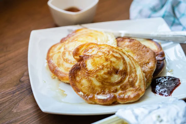 Fluffy pancakes with butter and maple syrup, close view