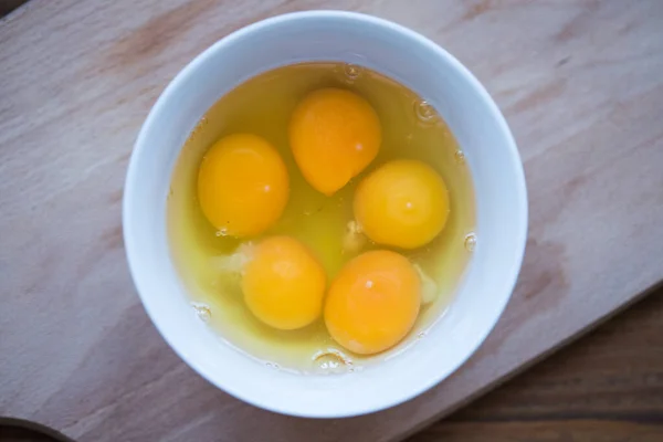 生の卵 白いボウルに割れた卵の写真 トップビュー — ストック写真