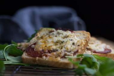 Salam peyniri ve fesleğen yapraklı tost, taze hazırlanmış lezzetli, besleyici, yakın plan kahvaltı.