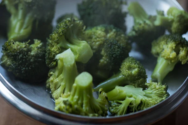 Fresh cooked broccoli with steam rising close up shot of vegetables full of vitamins for people on a diet