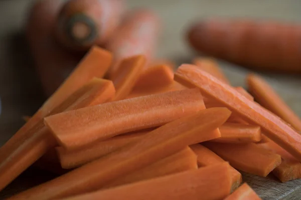 Tahta bir tahtanın üzerinde havuçlar dilimlenmiş. Yakından bak. Sağlıklı kızartma hazırlığı