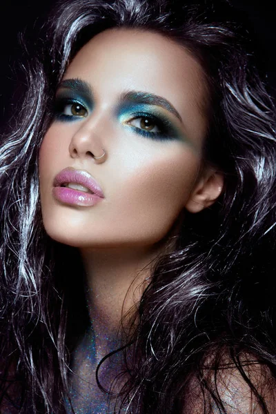 Sköna flicka med blått glitter i ansiktet — Stockfoto