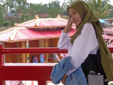 Kediri, Doğu Java Endonezya - 17 Şubat 2019: Kore 'nin geleneksel elbisesi Hanbok' ta Gyeongbokgung Sarayı 'nda ve kiraz çiçekleri açan ziyaretçi.