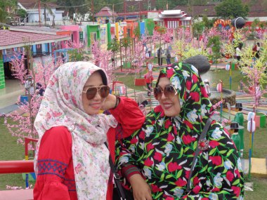 Kediri, Doğu Java Endonezya - 17 Şubat 2019: Kore 'nin geleneksel elbisesi Hanbok' ta Gyeongbokgung Sarayı 'nda ve kiraz çiçekleri açan ziyaretçi.