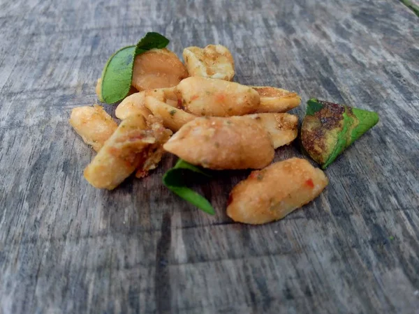 Ahşap arka planda kaffir yapraklı baharatlı fıstık.