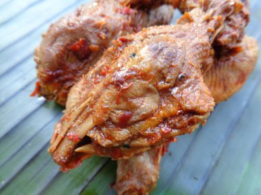Muz yaprakları üzerinde baharatlı ızgara tavuk kafası (kepala ayam bakar pedas). Endonezya mutfağı sokak yemekleri.