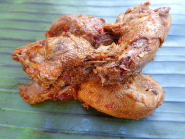 Muz yaprakları üzerinde baharatlı ızgara tavuk kafası (kepala ayam bakar pedas). Endonezya mutfağı sokak yemekleri.