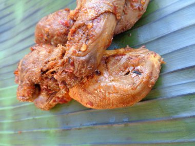 Muz yaprakları üzerinde baharatlı ızgara tavuk kafası (kepala ayam bakar pedas). Endonezya mutfağı sokak yemekleri.