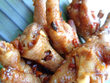 Muz yaprakları üzerinde ızgara tavuk budu (ceker ayam bakar pedas). Endonezya mutfağı sokak yemekleri.