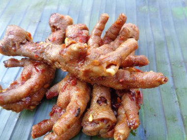 Muz yaprakları üzerinde ızgara tavuk budu (ceker ayam bakar pedas). Endonezya mutfağı sokak yemekleri.