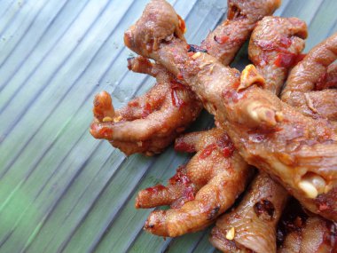 Muz yaprakları üzerinde ızgara tavuk budu (ceker ayam bakar pedas). Endonezya mutfağı sokak yemekleri.