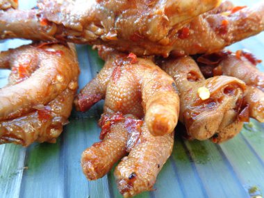 Muz yaprakları üzerinde ızgara tavuk budu (ceker ayam bakar pedas). Endonezya mutfağı sokak yemekleri.