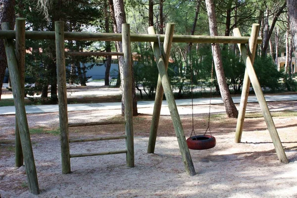 Do-it-yourself children's playground in the village. Natural eco-friendly materials. Empty playground without children. Ladder and swing from the tire