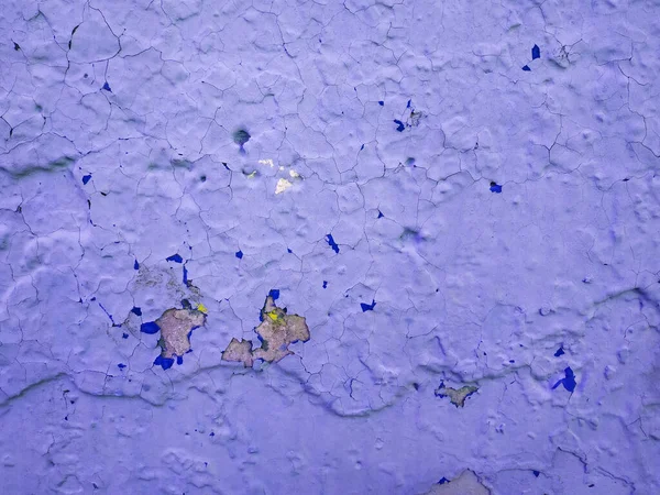 Concrete is puttied and painted with purple paint. Retro ruined wall, exposure to moisture and dampness. Violet texture of the wall with uneven paint, poor repair. Insecure construction
