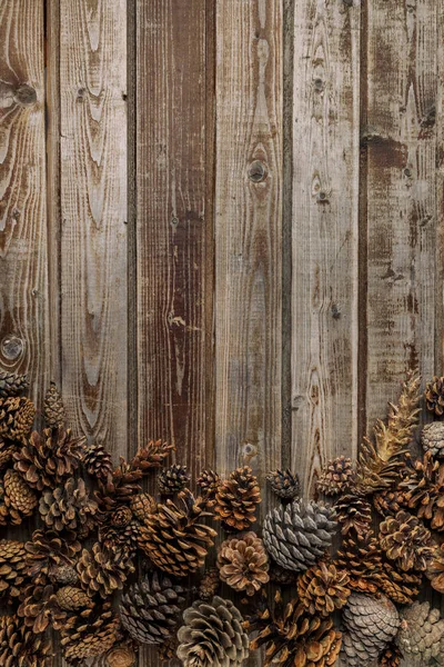 Cones de pinheiro na mesa da sala de estar dentro de uma tigela de madeira. Conceito de decoração de Natal. Fundo quente . Fotos De Bancos De Imagens