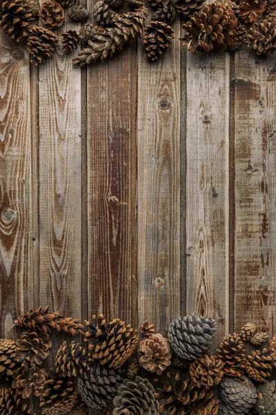 Cones de pinheiro na mesa da sala de estar dentro de uma tigela de madeira. Conceito de decoração de Natal. Fundo quente . Imagens De Bancos De Imagens Sem Royalties