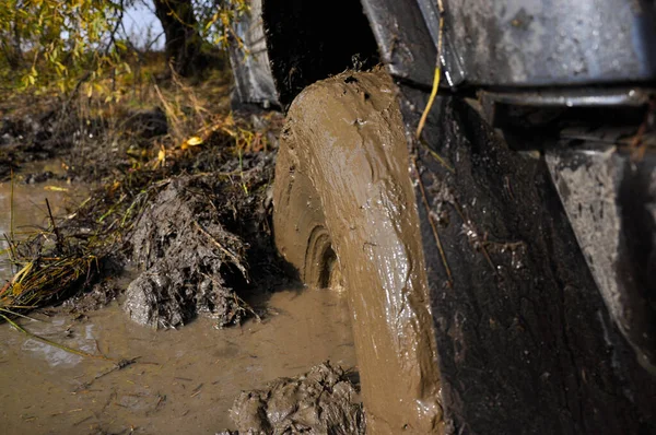 Uma roda suja de um SUV preso na lama durante uma competição — Fotografia de Stock