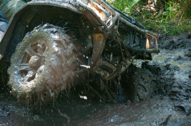 Zor bir bölümün üstesinden gelirken Çamurda Atv tekerlekleri.