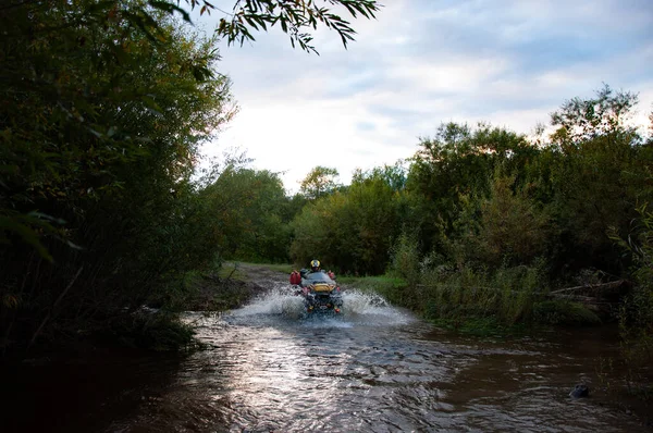 Quad ATV cavalga através da água na floresta no verão . — Fotografia de Stock