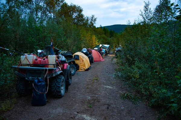 Verschillende Atvs en tentenkamp op een bosweg in de bergen. Rechtenvrije Stockafbeeldingen