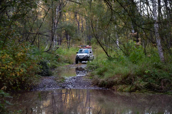4x4 SUV during the autumn expedition in difficult conditions. — Stock Photo, Image