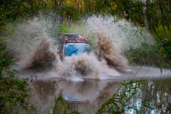 4x4 Suv tijdens de herfstexpeditie in moeilijke omstandigheden. Stockfoto