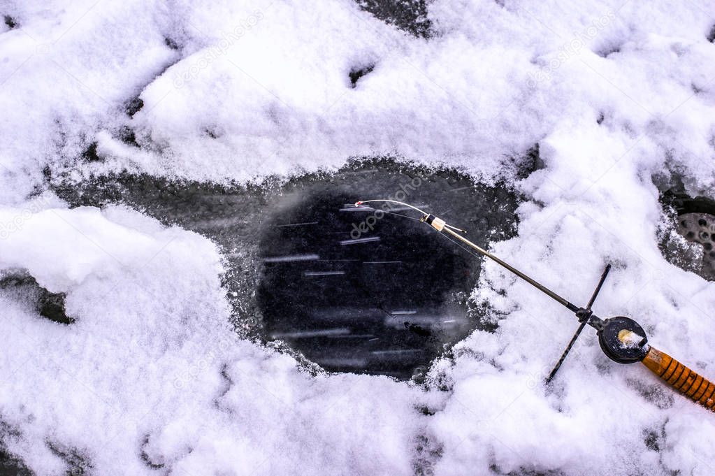 Hole in the ice and fishing rod