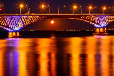 Nehir genelinde büyük bir köprünün parlak gece ışıkları düny vardır